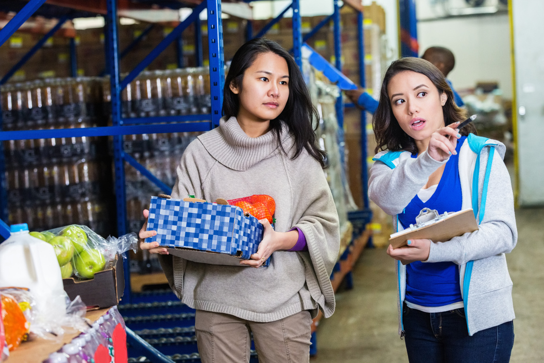 Women working together in food bank distribution warehouse