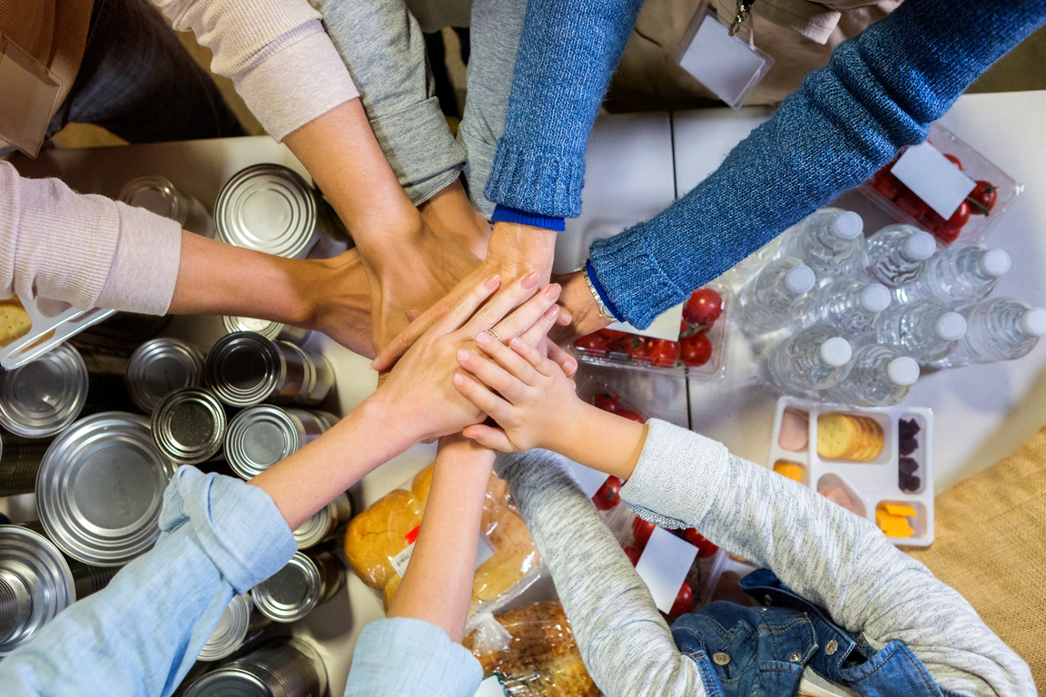 Food bank volunteers with hands together